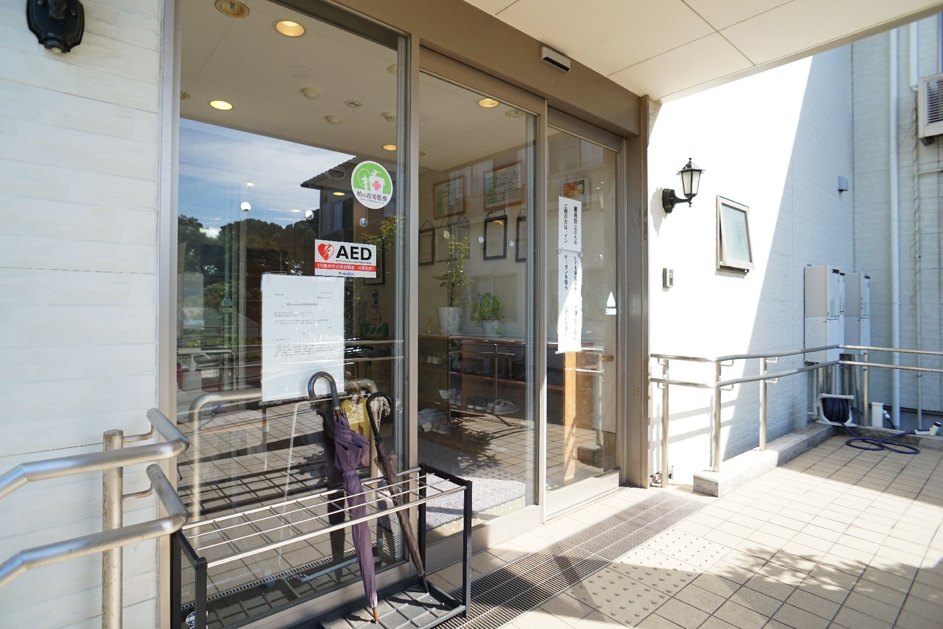 日当たりがよく緑豊かな屋外で、ノートパソコンを片手に楽しそうに笑う男性とそれに応じる女性