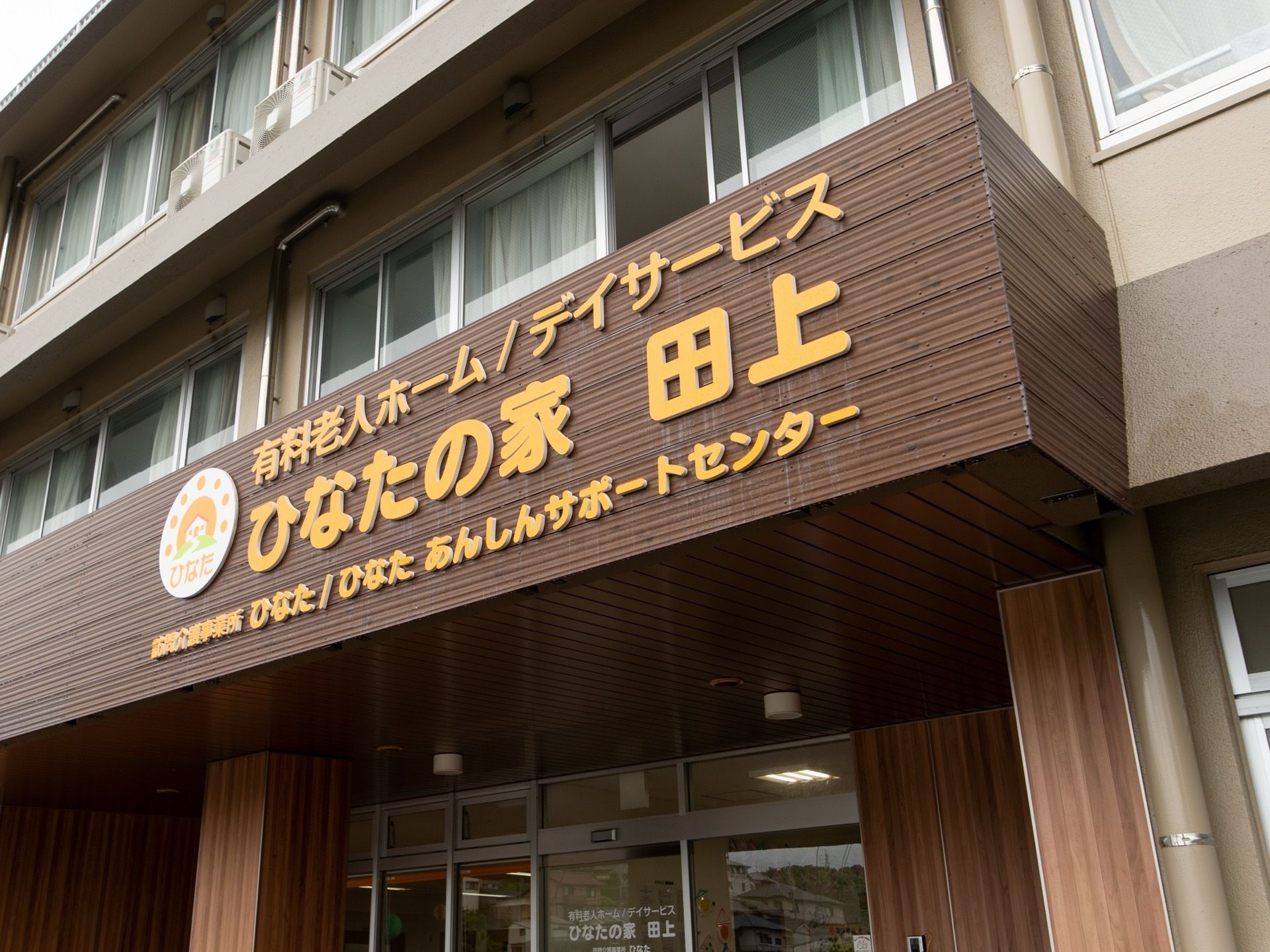 建物の入り口の上に、大きく施設名が表示してある。エントランス前には、広い屋根のあるスペースが確保されている。