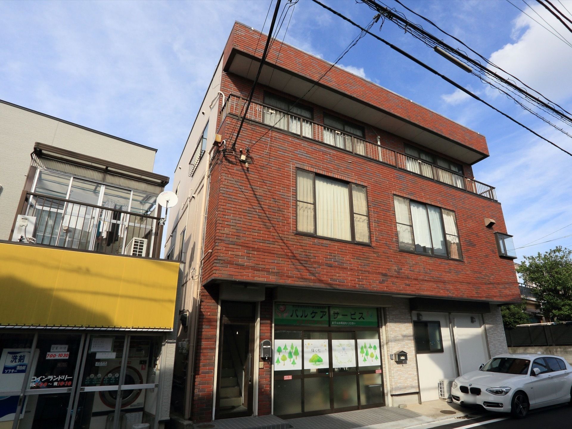 レンガ調の3階建ての建物になっており、左側には2階へ上がる階段がある。3階にはベランダがあり、柵が取りつけられている。