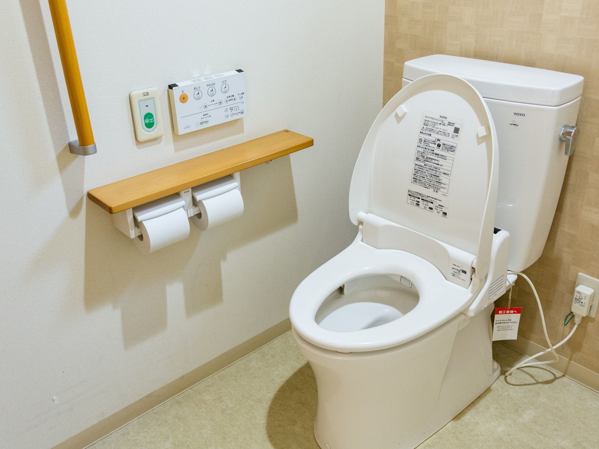 トイレは広々としていて、白を基調とした内装となっている。壁には茶色い手すりとトイレットペーパー掛け、緊急呼び出しボタンなどが設置されている。