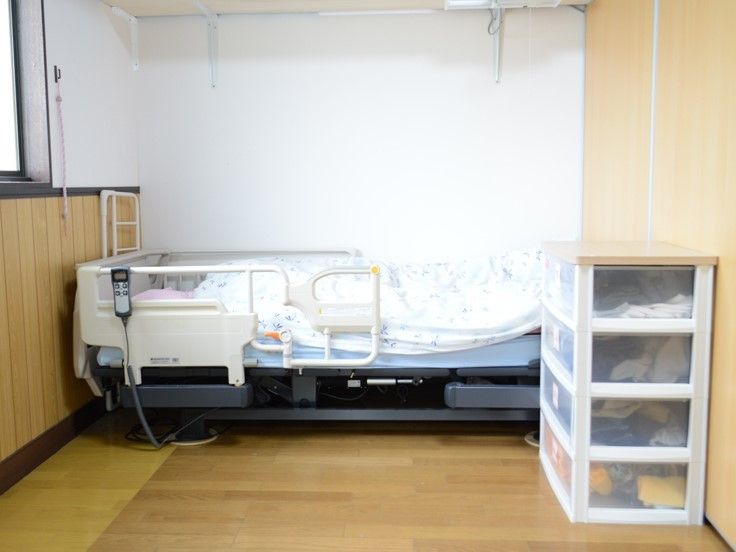 シンプルな居室には収納棚と介護用ベッド、窓がある。