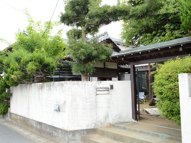 白壁に囲まれた住宅には立派なもんが付き、中には広い庭と和風の建物があるのは見える。
