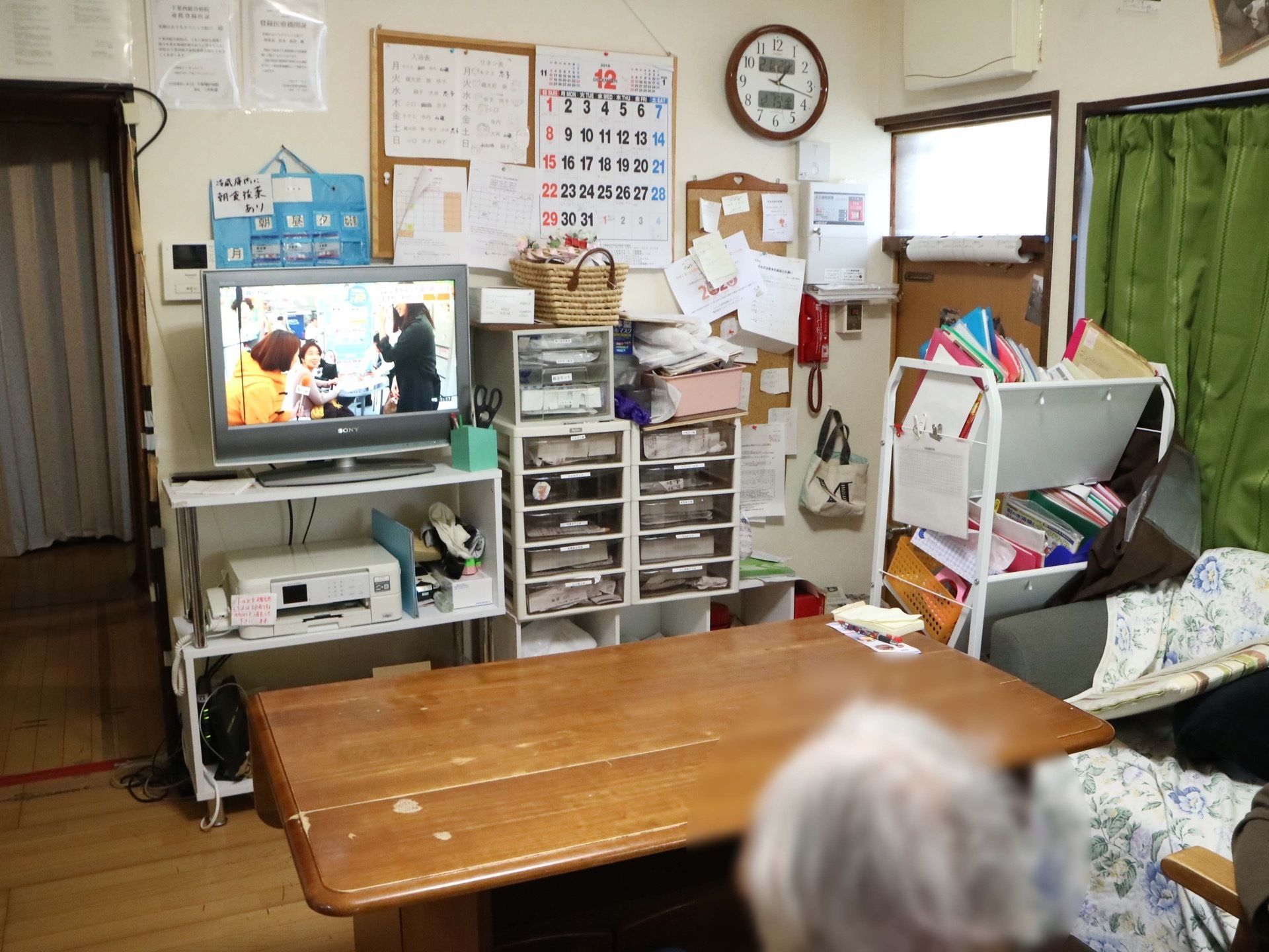 生活感が感じられるスペースである。テレビ、プリンターなど家具一式が揃っている。壁には入居者様の薬が掛けてある。