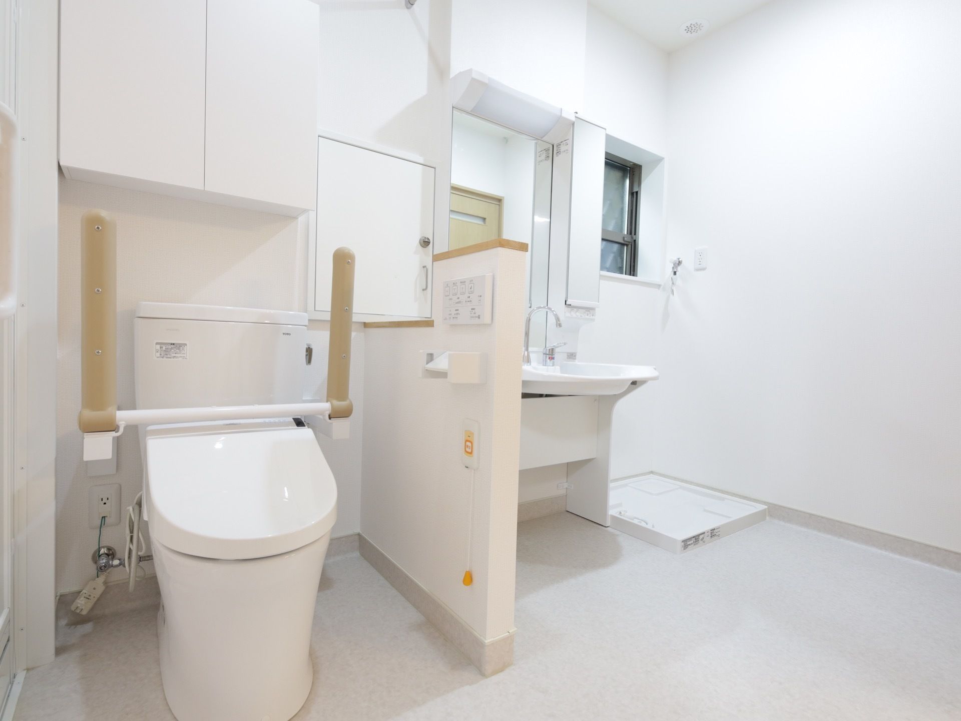 洗面スペースとトイレが一体となった清潔感のある空間。洗面台の横には洗濯機を置く防水パンが設置されている。