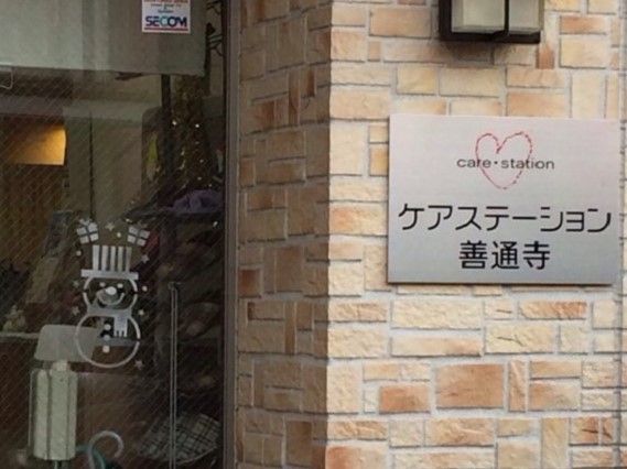 雪だるまのイラストが目を引くエントランスのガラス戸。セキュリティ会社のステッカーも貼られている。
