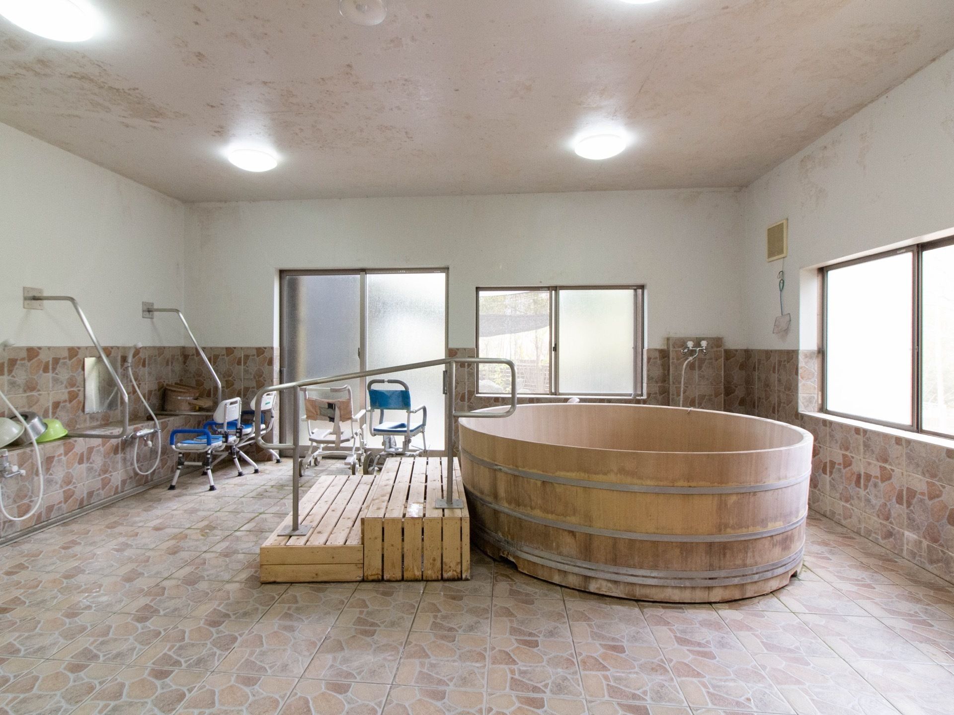 広々とした明るい大浴場である。浴槽は、ヒノキの大きな桶で、手すりのついた階段が備わっている。複数人で浸かれる。