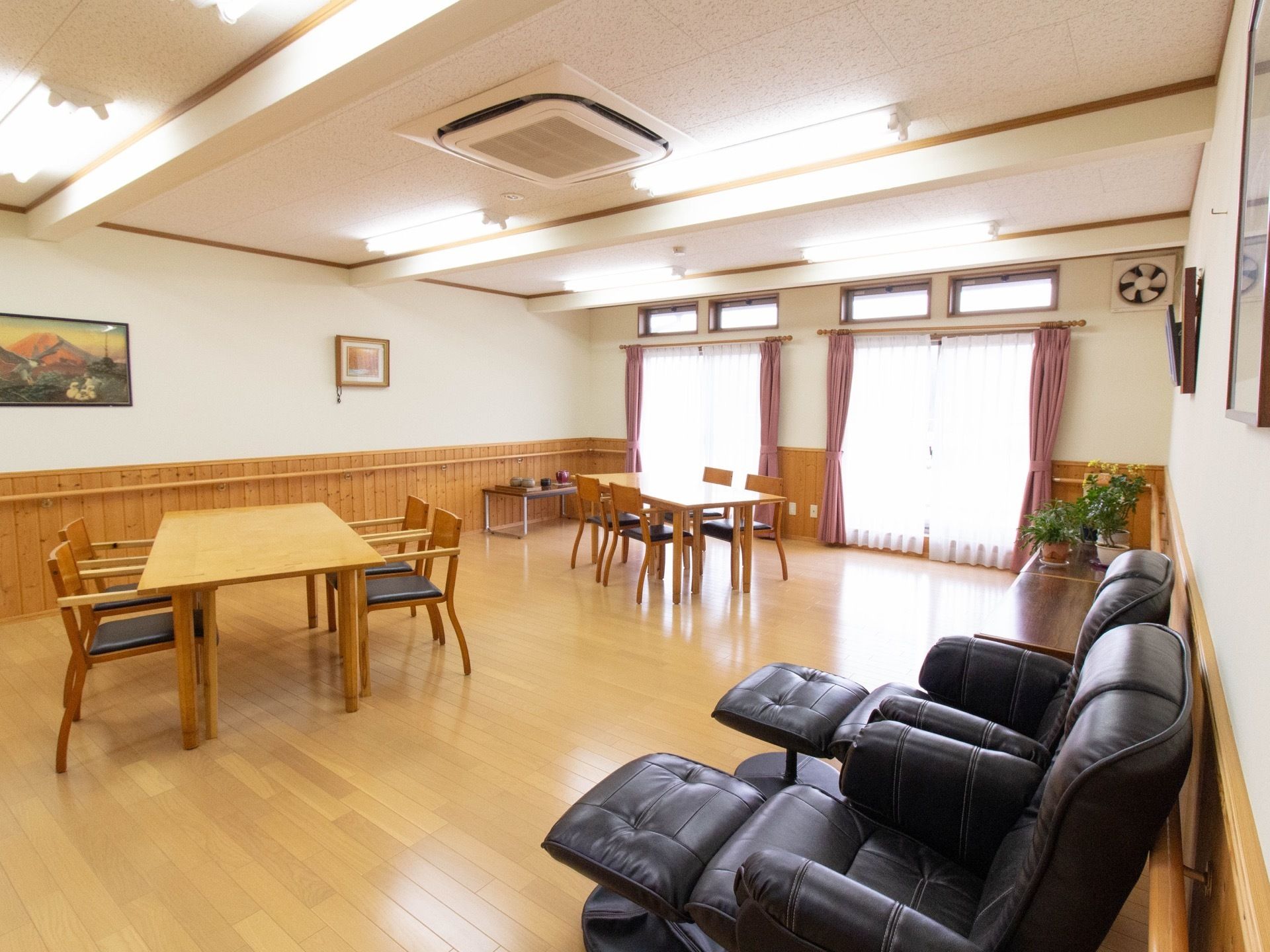 広々として、日当たりのよい明るい食堂である。４人掛けのダイニングテーブル、足置き付きのソファが２脚置かれている。エアコンが完備されている。