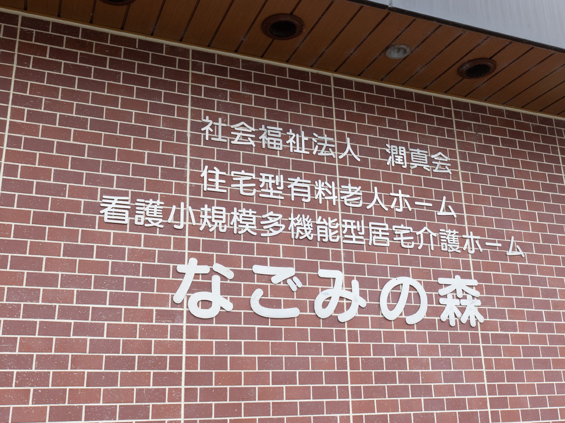 レンガの外壁に白い文字で大きく書かれている施設名
