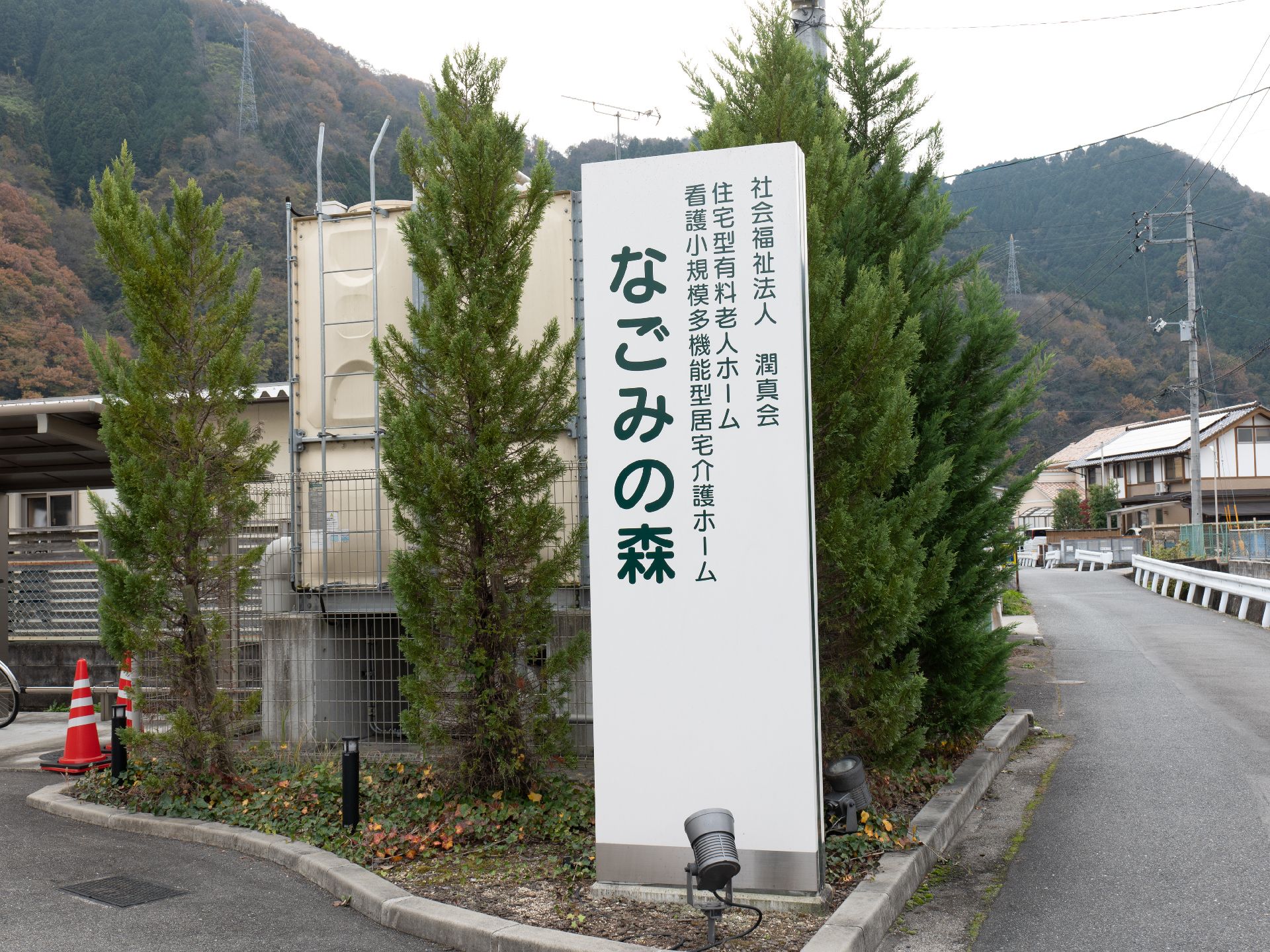 車いすの女性と同じ視線で話している介護スタッフ。やわらかい表情で散歩している様子