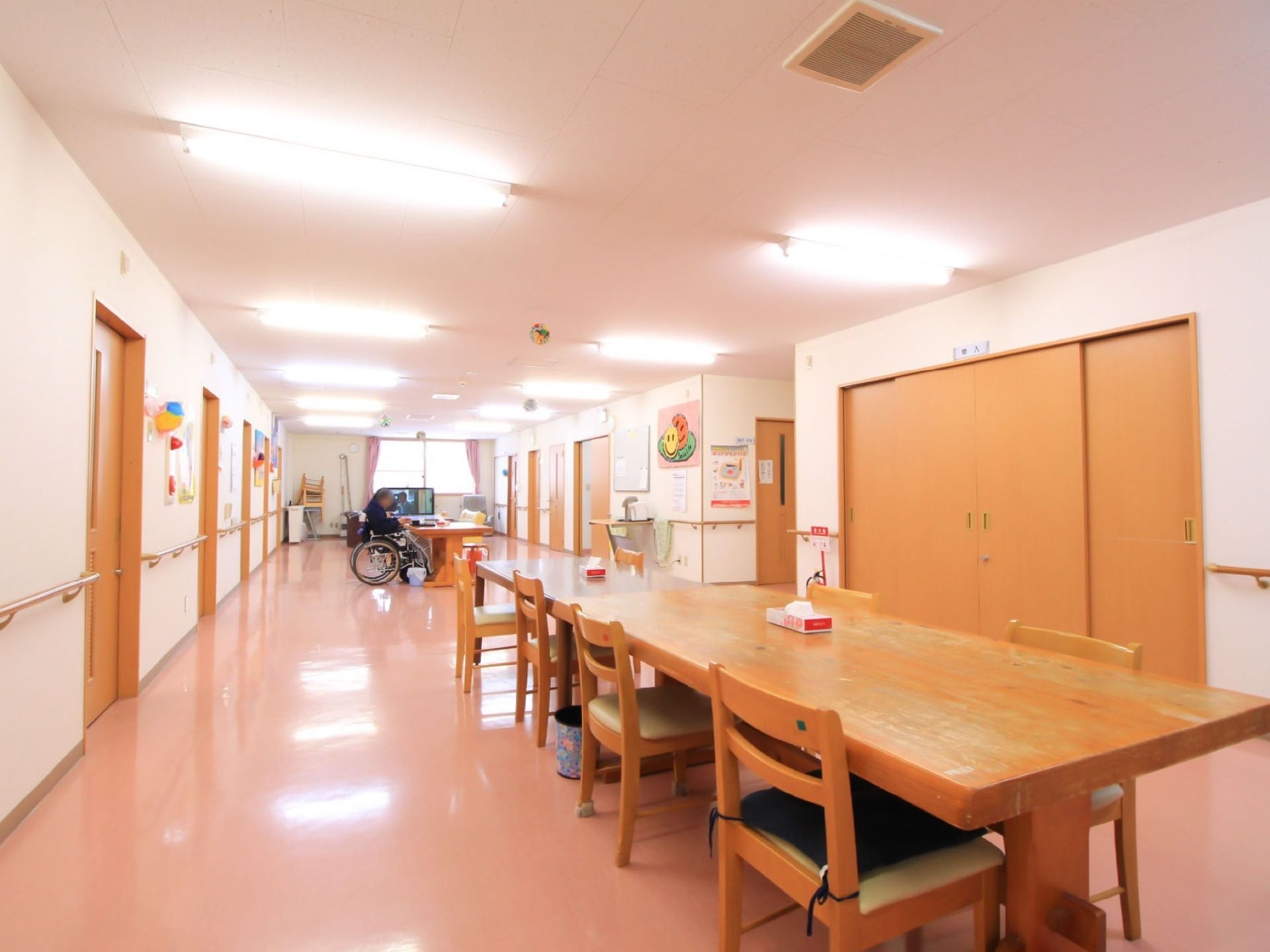 椅子とテーブルが設置された広い共有スペースである。壁には手すりがあり、つかまりながら移動することができる。