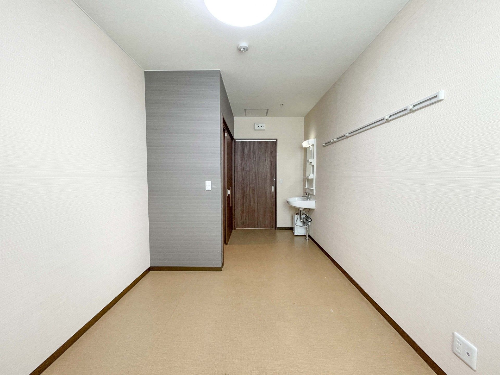 高齢者の方にタオルをかけてマッサージしているスタッフと振り返りながら会話する女性の様子