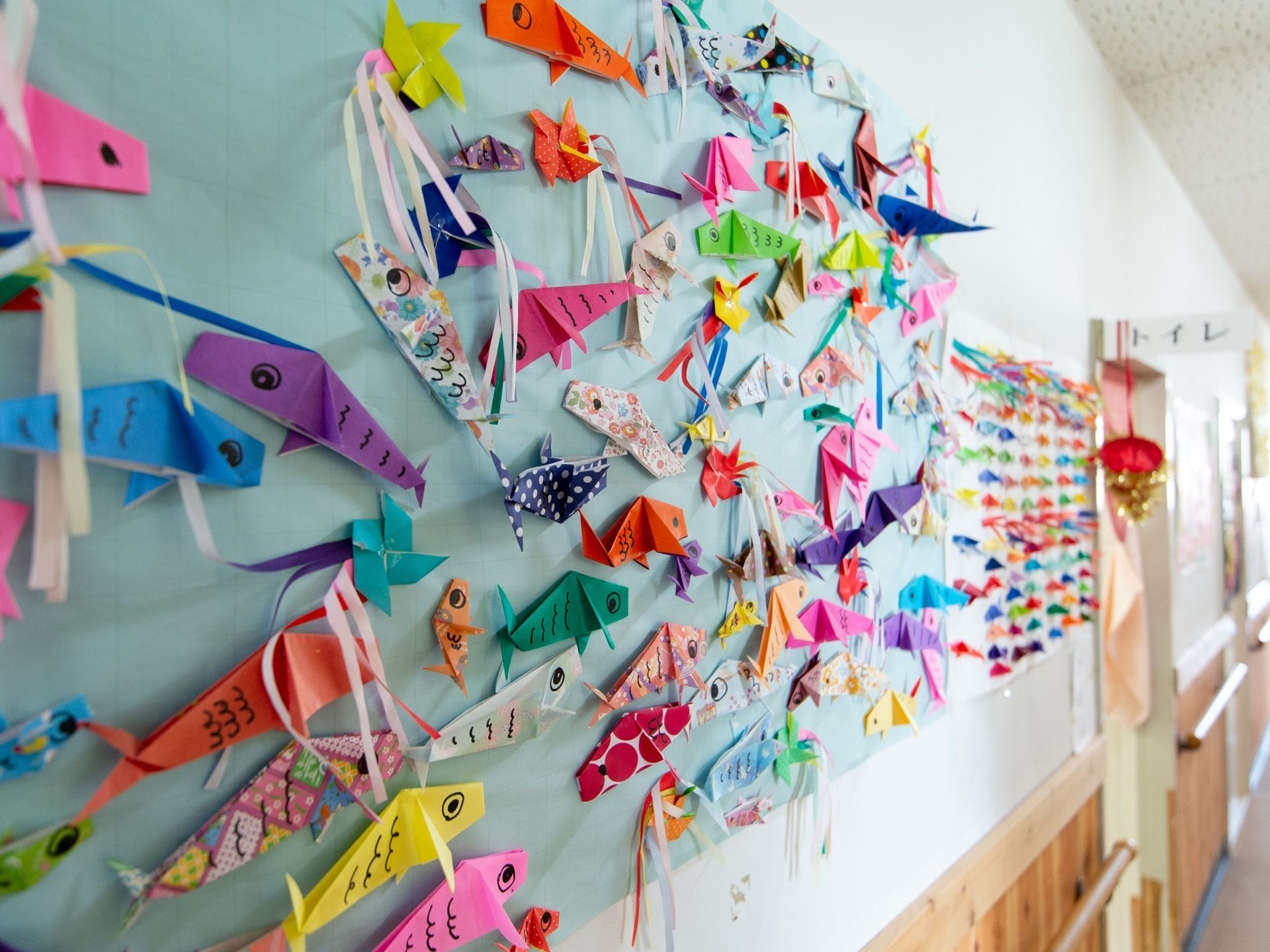 壁に展示されている紙で作った魚のアート