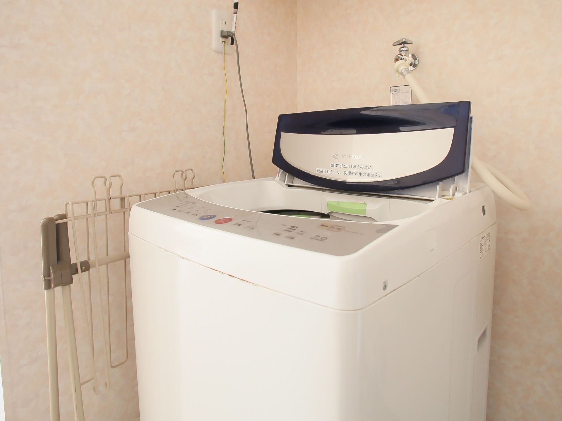 洗濯室に設置された白い洗濯機である。施設では、入居者様自身で洗濯を行っていただけるように専用スペースを設けている。