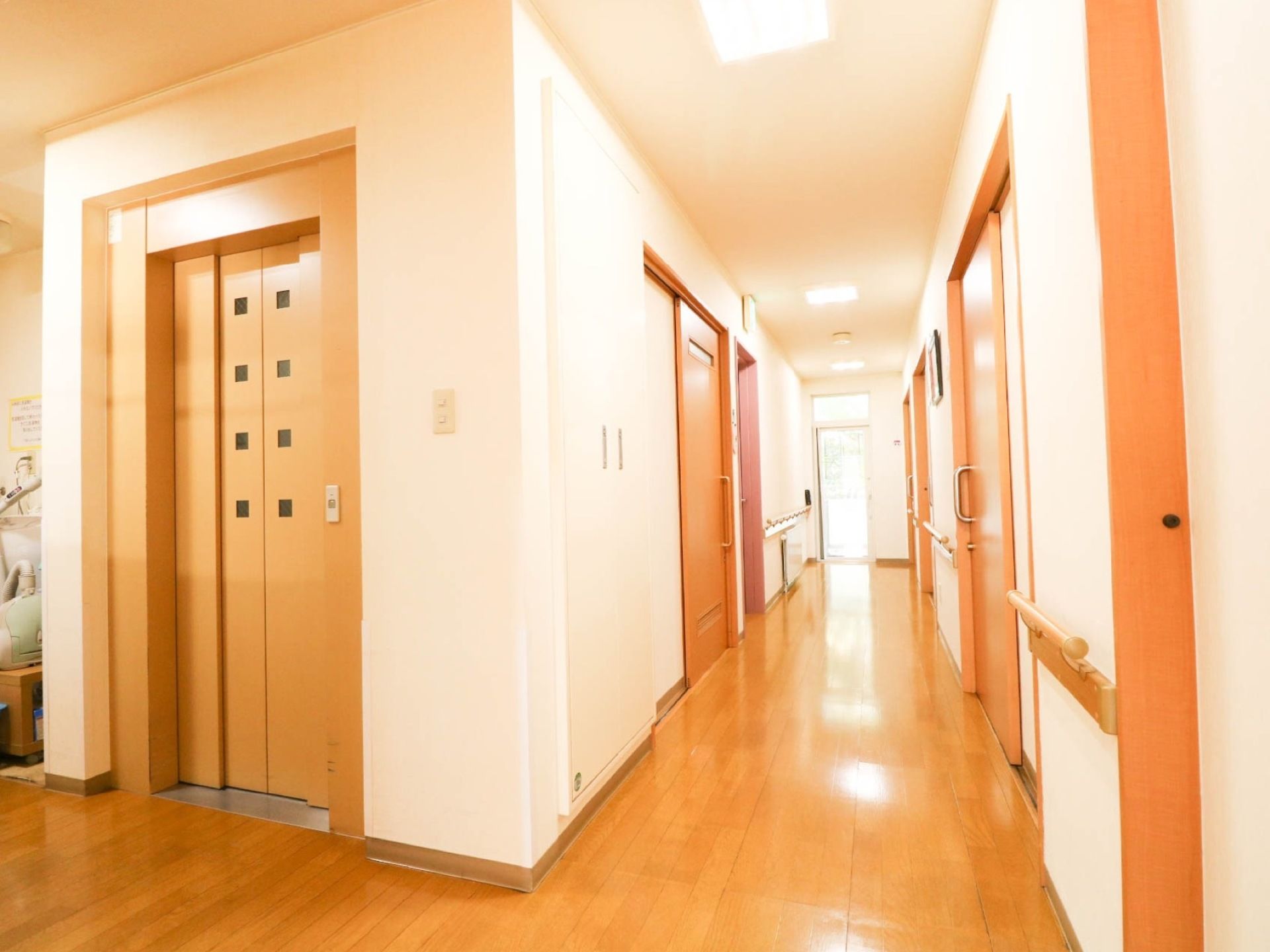 エレベーターが1基設置されている。通路は明るく、床はフローリングである。壁には手すりがある。