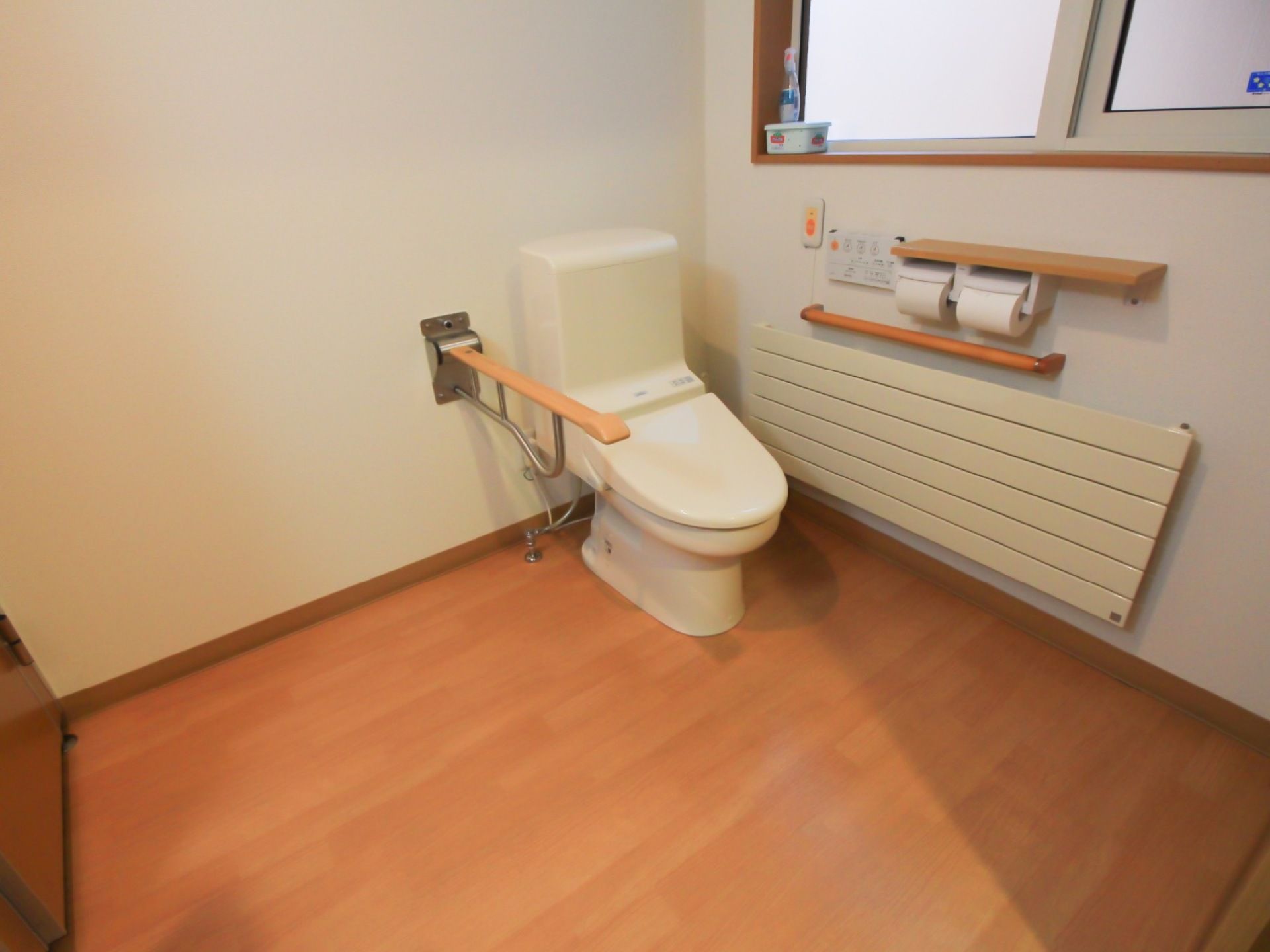 便座の右側に壁があり、トイレットペーパーホルダーや手すり、緊急通報装置が付いている。その上には小窓があり、掃除用シートがある。
