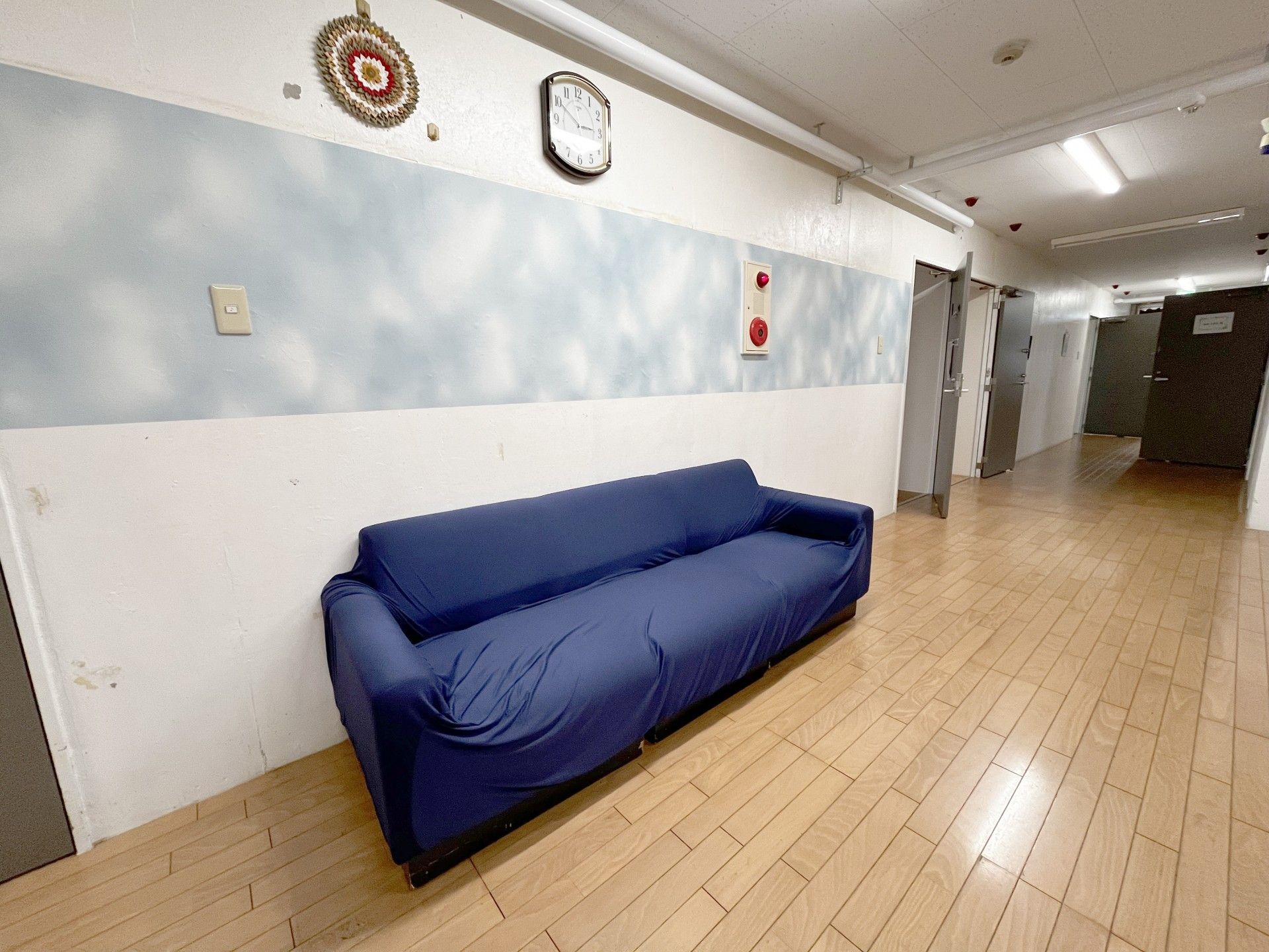 青いソファのある廊下