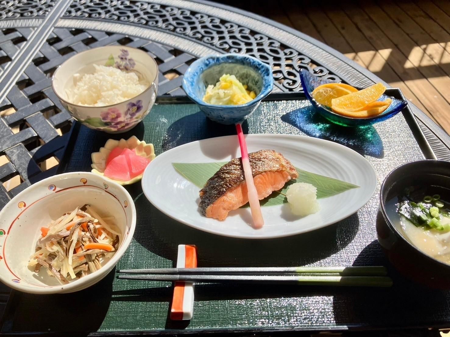 一汁三菜のメニューが器に盛りつけられ黒いプレートに並べられた食事