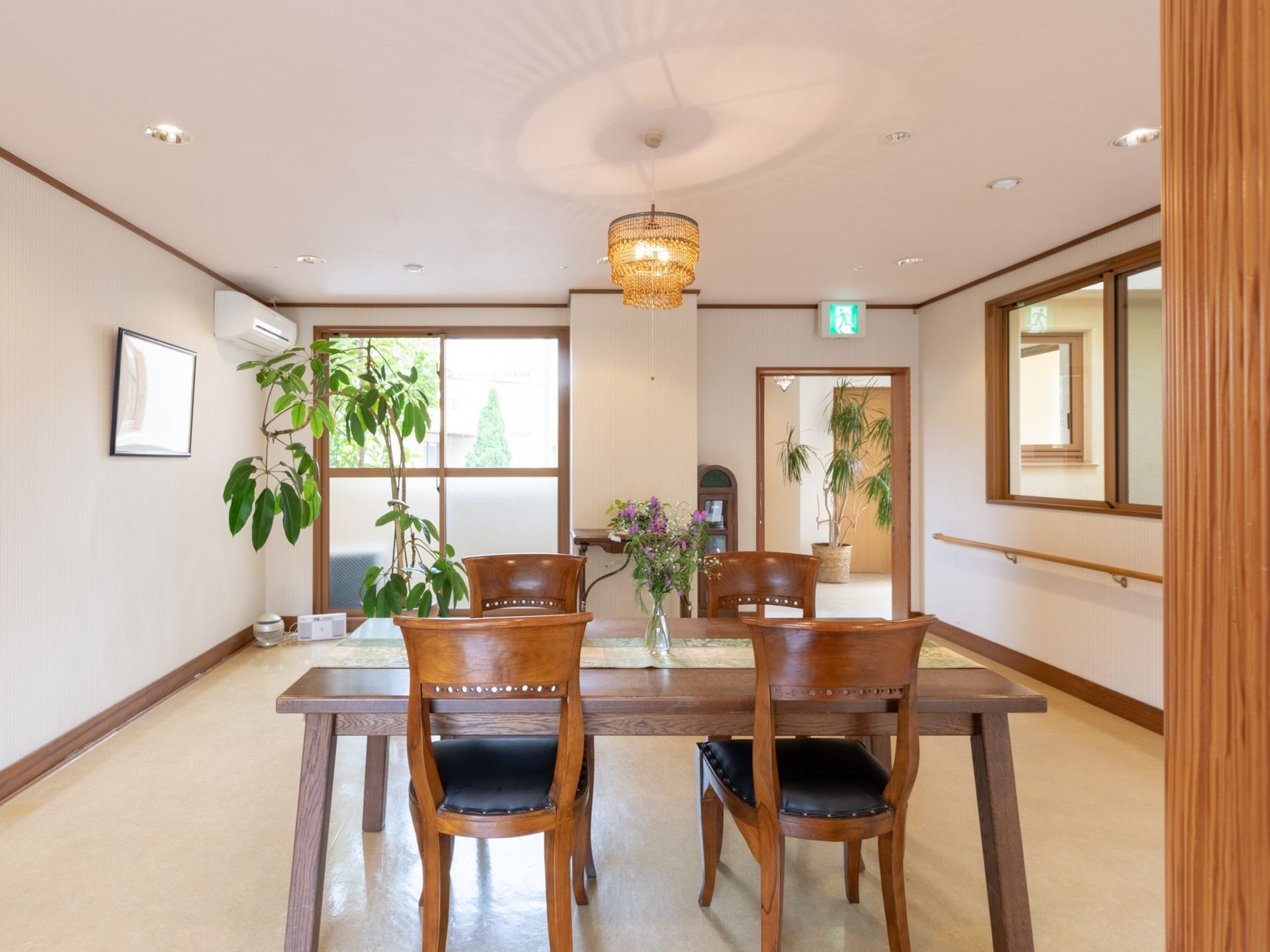 間取りの広い共有スペースの中央に、４人掛けのテーブルセットが置かれている。エアコンが完備されており、年中快適に過ごすことができる。
