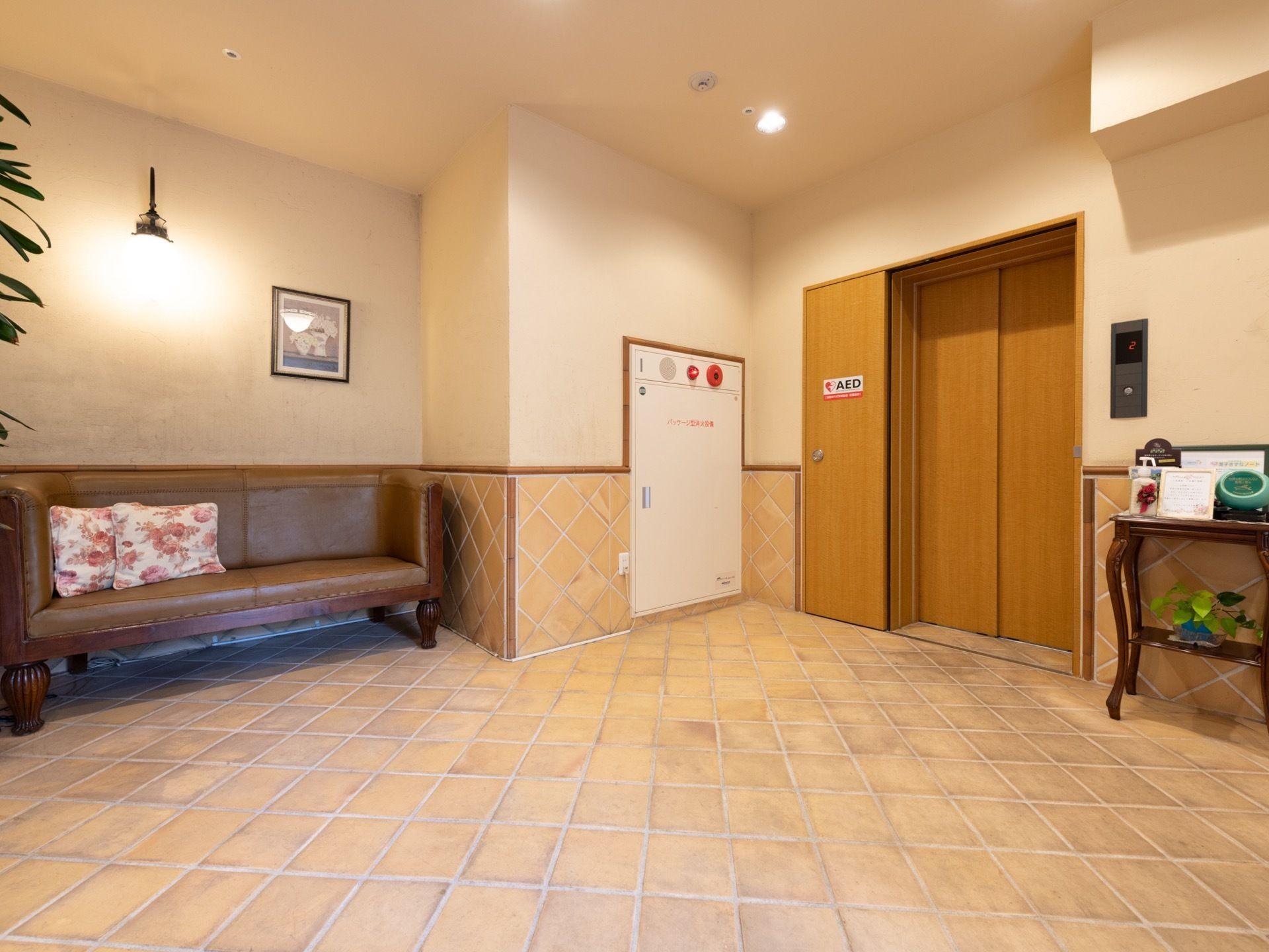 エレベーターホールには、落ち着きのある大きなソファが配置されている。床には滑りにくいタイルが敷かれ、安全に歩行いただけるよう配慮されている。
