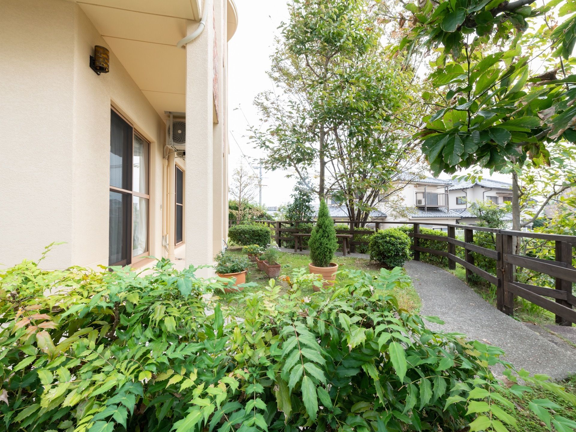 庭には鉢植えや植木がたくさんあり、外からの自然な目隠しとなっている。居室の窓越しに眺めることができる。