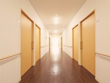 両サイドに手すりが付いた廊下。各居室には大きな引き戸が付いている。