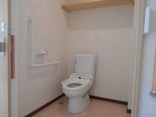 広いトイレにはふたのない便座が設置され、壁にはエル字型の手すりが設置され、スペースも広い。