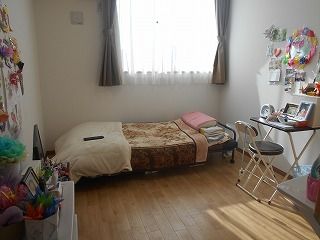 日当たりのいいフローリングの部屋には寝具付きのベッドやテーブルセットが置かれ、創作作品が飾られている。