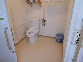 手すりがドアのそばにも設置され、トイレは広く、ふたがなくされ、洗面所は車いす対応の仕様。