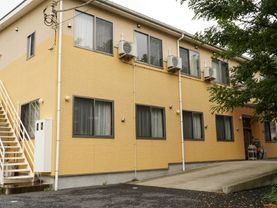 黄色を基調とした住宅街に馴染む外観の老人ホーム