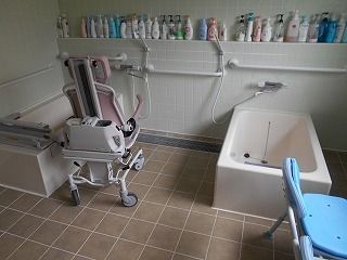 二つ一人用の浴槽が設置され、左側にはレールが付いた浴槽や車いすタイプのリフトがある。