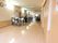 トイレが完備されている共有スペースである。明るい木目調のフローリングに4人掛け用のテーブルセットが設置されている。