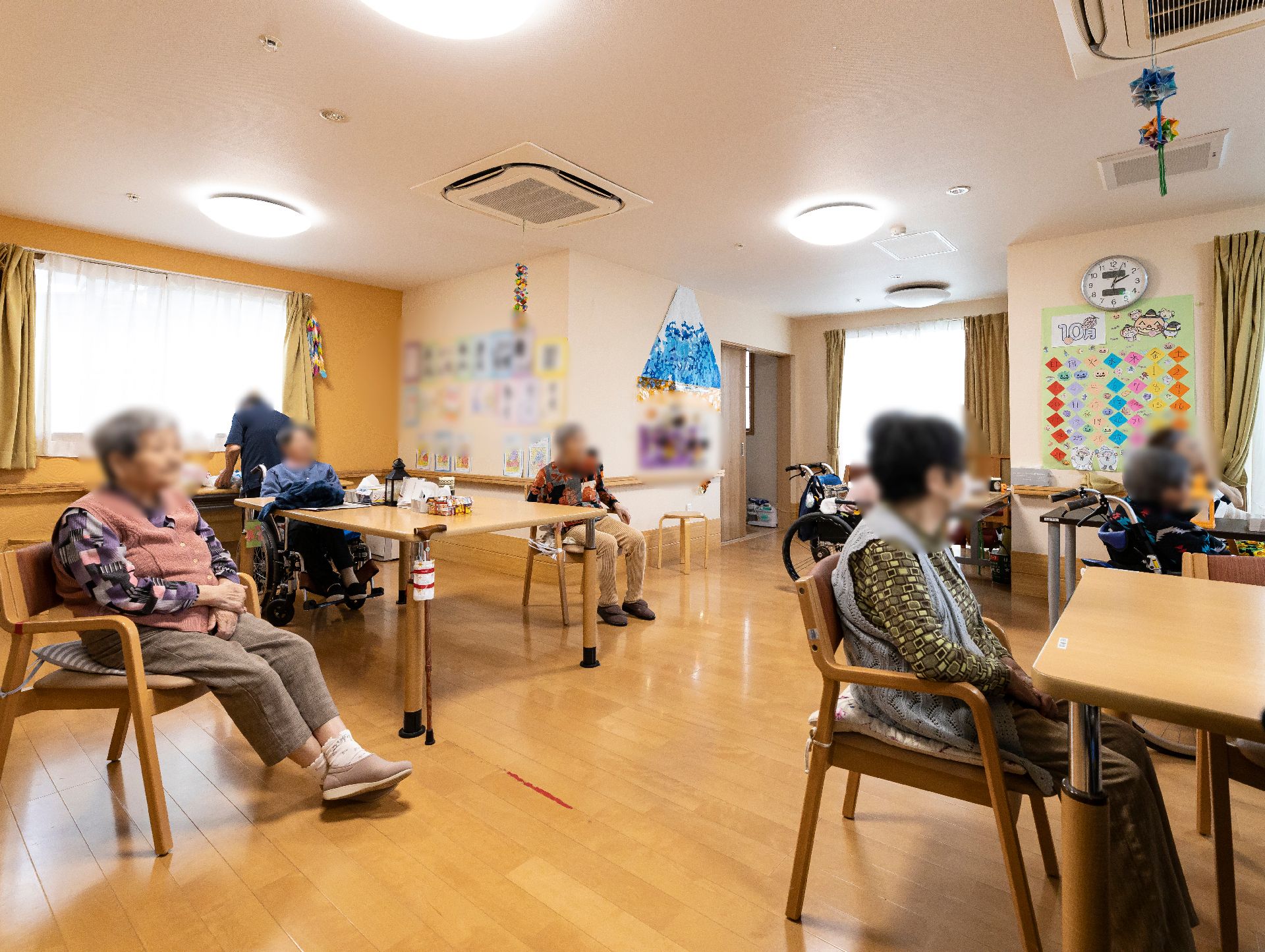 車椅子に座った高齢女性の話を聞く女性ヘルパー