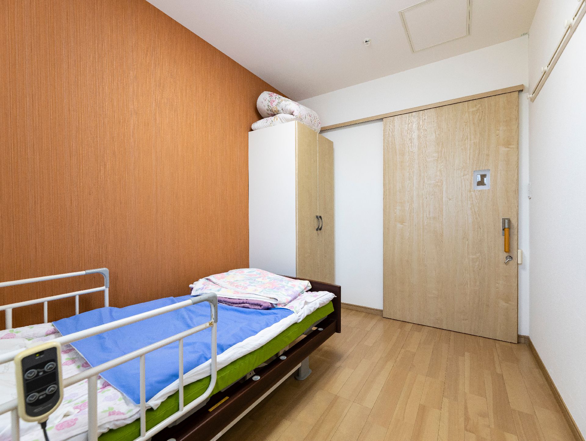 車椅子に座って微笑む高齢女性と介助をする女性ヘルパー