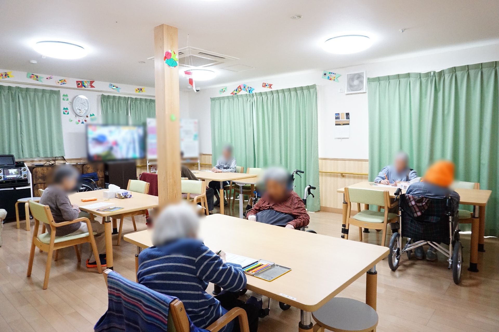 手を振る車椅子に座った高齢女性と後ろで介助をする女性ヘルパー