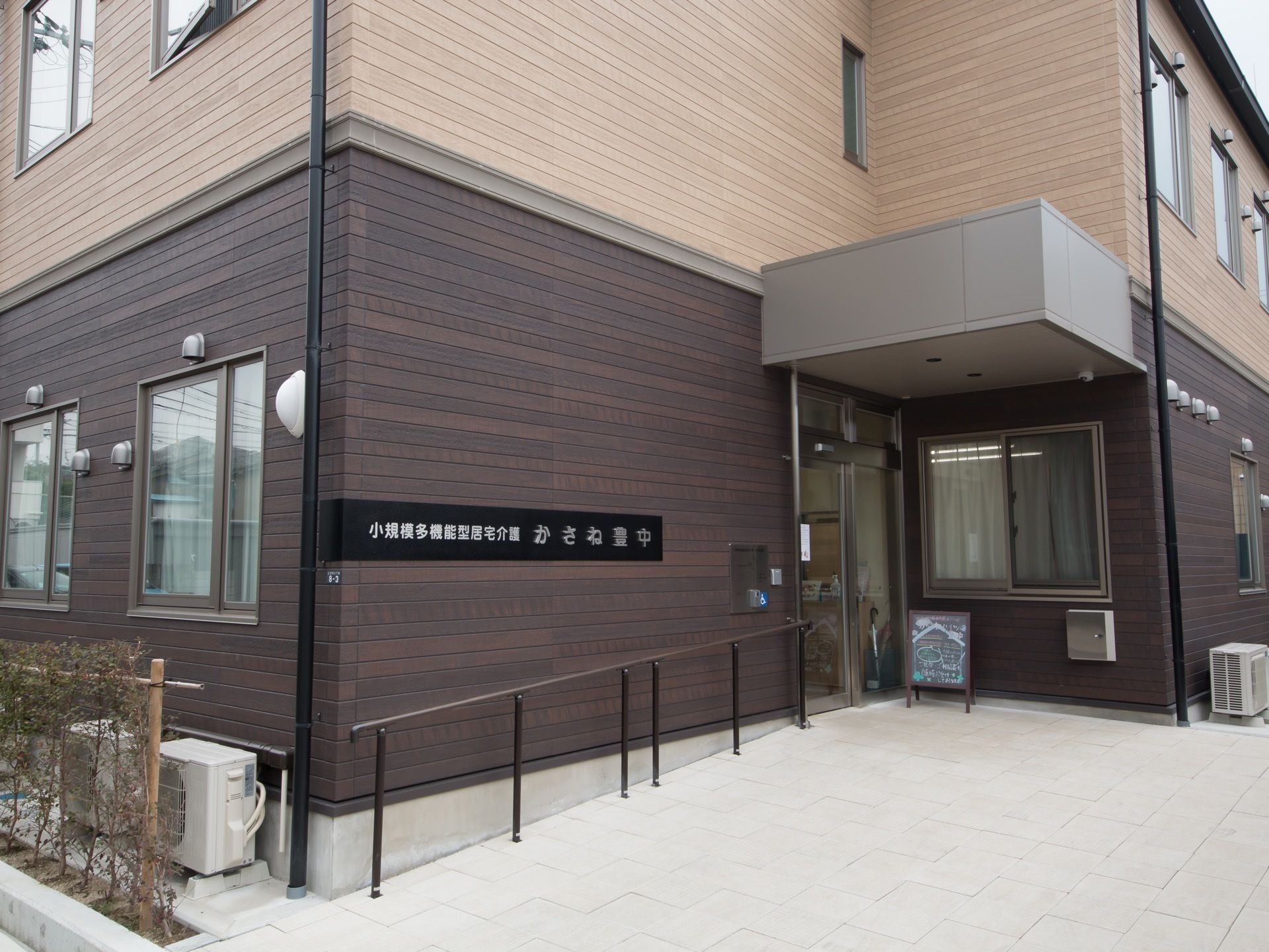 施設の外壁は、黒色と茶色のツートンカラーとなっている。入口には、ガラス張りの自動ドアが設置されている。