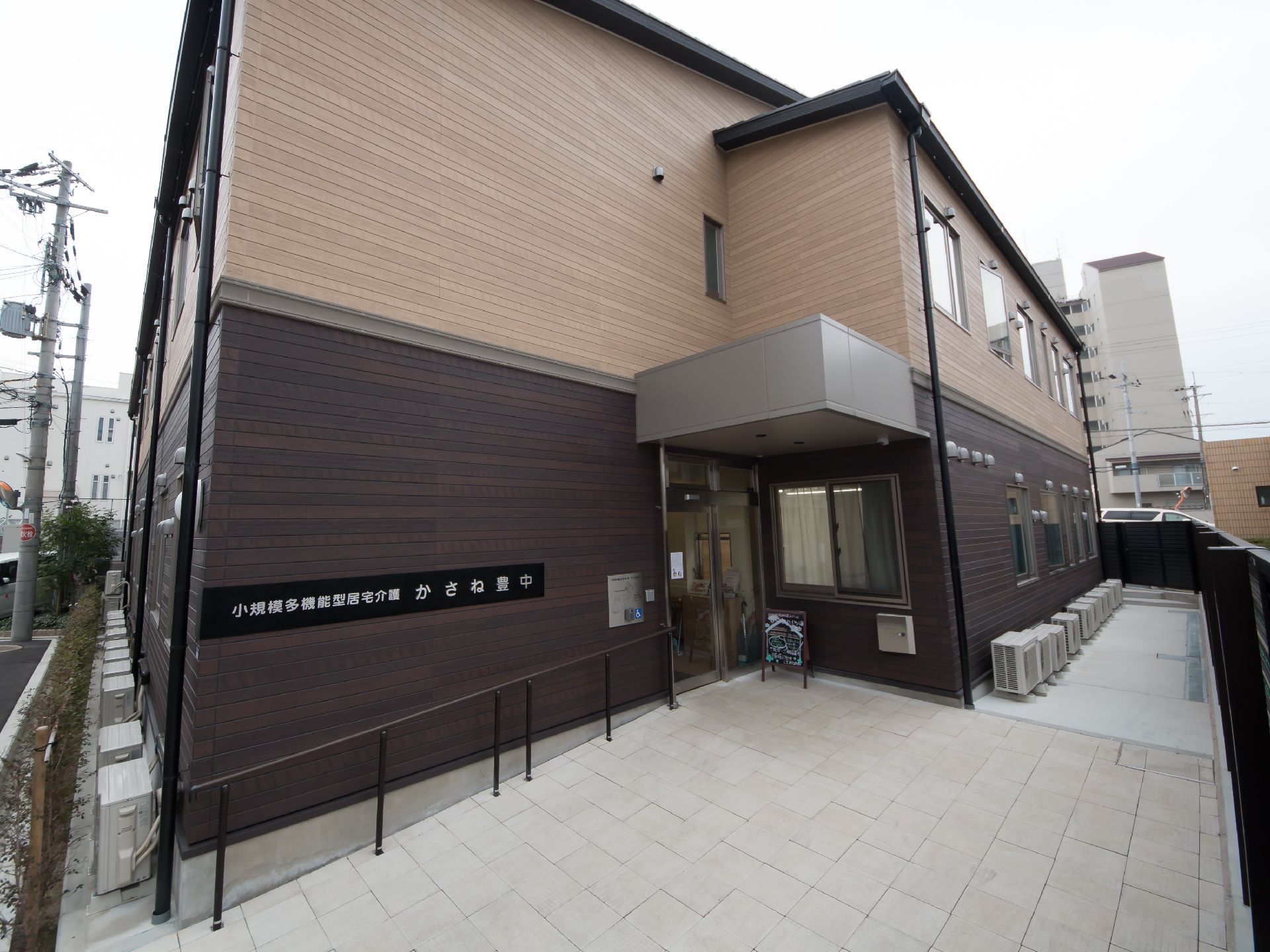 ブラウンとベージュの2階建ての建物。外壁にホームの名前が書かれている。