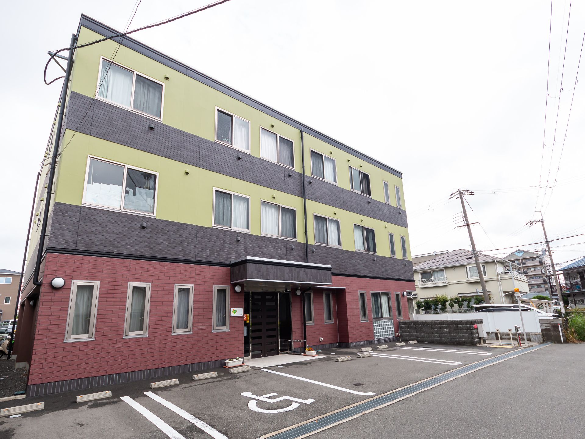３階建てで、モダン色の落ち着いた色合いが特徴の施設の外観