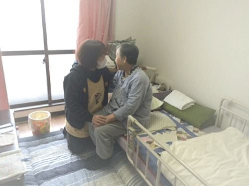 スタッフと会話する高齢者。施設内の一室で話している様子