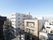 ホーム上から見た風景。道路向かい側にはマンションが複数棟建っている。エアコンの室外機があり、洗濯物が干されているのが見える。