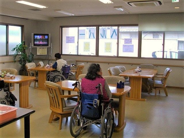 車いすの女性が座っているリビングスペースの様子。奥のほうにテレビが置いてある