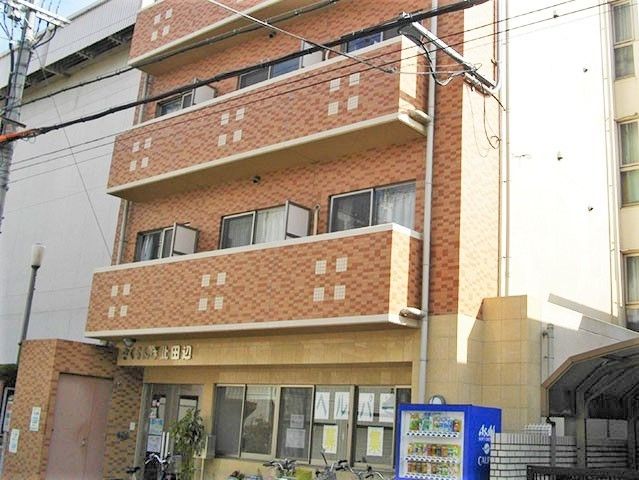 淡い色合いの鉄骨造の建物の写真。壁の色合いとかわいいデザインが印象的な建物
