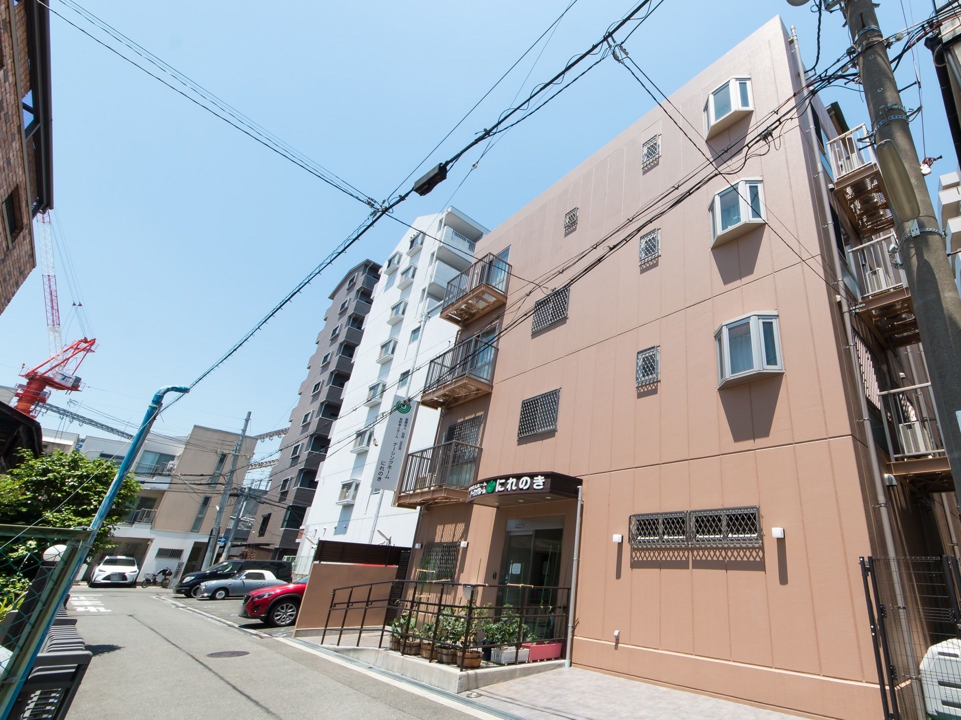 落ち着きのある色合いの4階建ての建物である。入口にはスロープが設置されているので、車椅子ご利用の方に無理なく出入りができる。