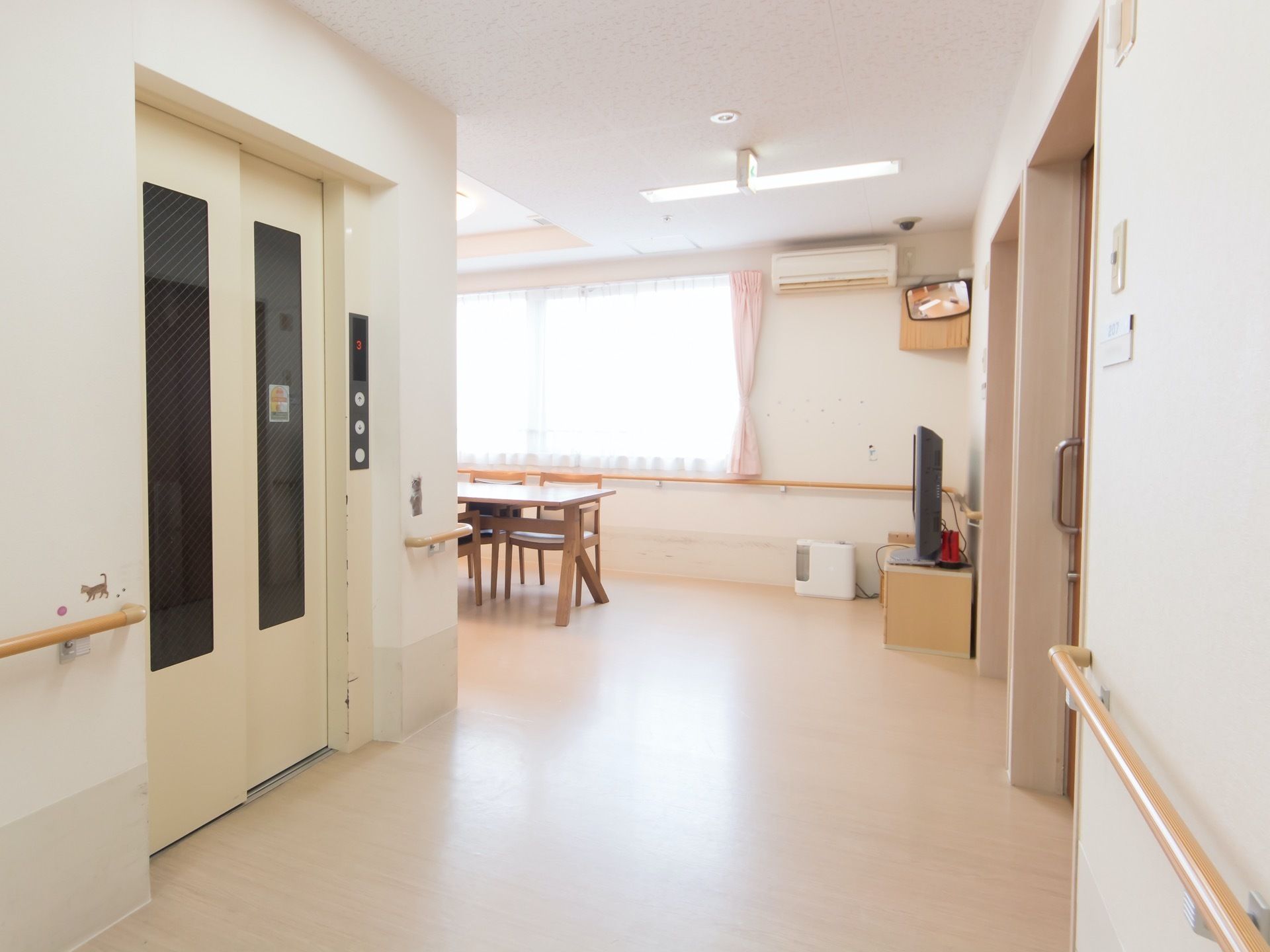広々とした通路が食堂につながっている。エレベーターが完備されている。両側の壁には手すりが設置されている。