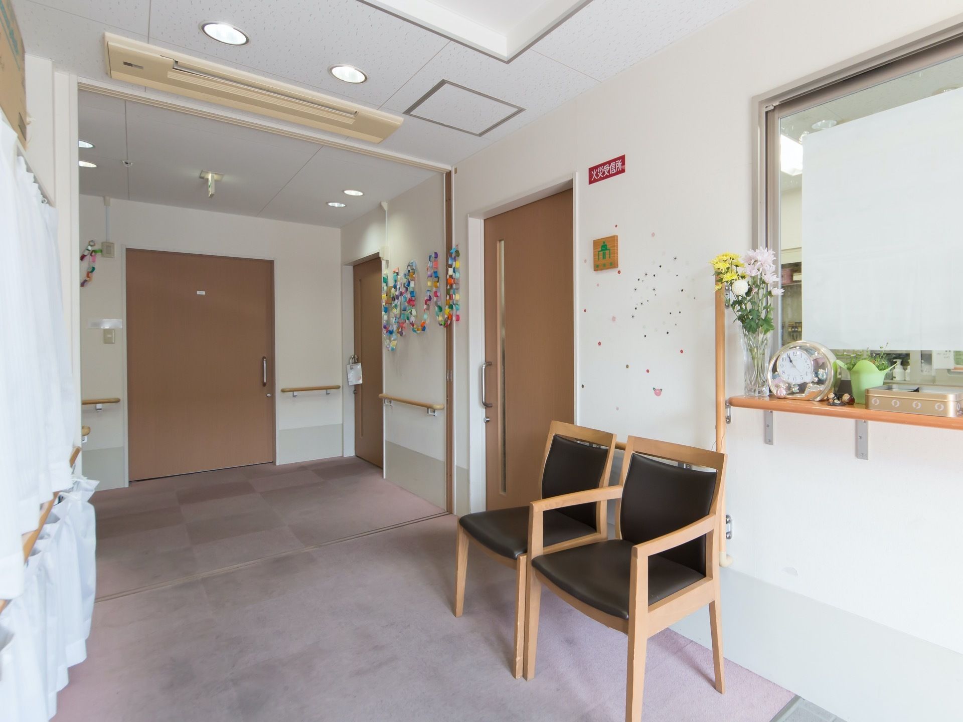 玄関と建物の境はバリアフリーになっており車椅子でも問題がない。靴の脱ぎ履きや休憩にご使用いただける椅子を置いている。