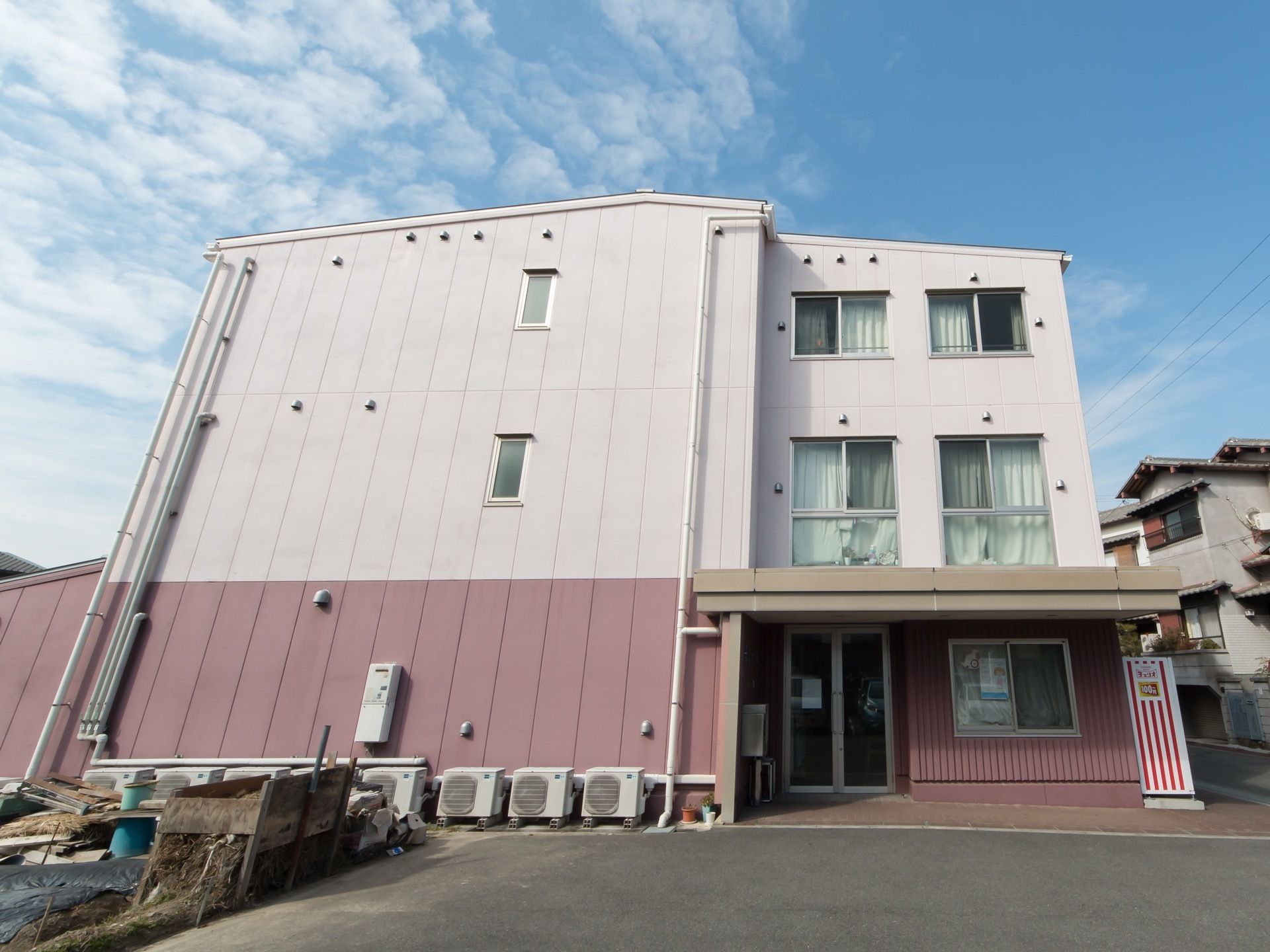 暖色で統一された建物である。大きな窓が複数設置されているが、施設内の様子は見えず、入居者様のプライバシーが守られている。
