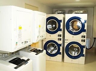 洗濯ルームないに洗濯機、乾燥機が置いてある施設内の写真。