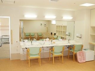共有スペースに置いてある椅子付きの洗面台。施設内の大き目な設備の写真