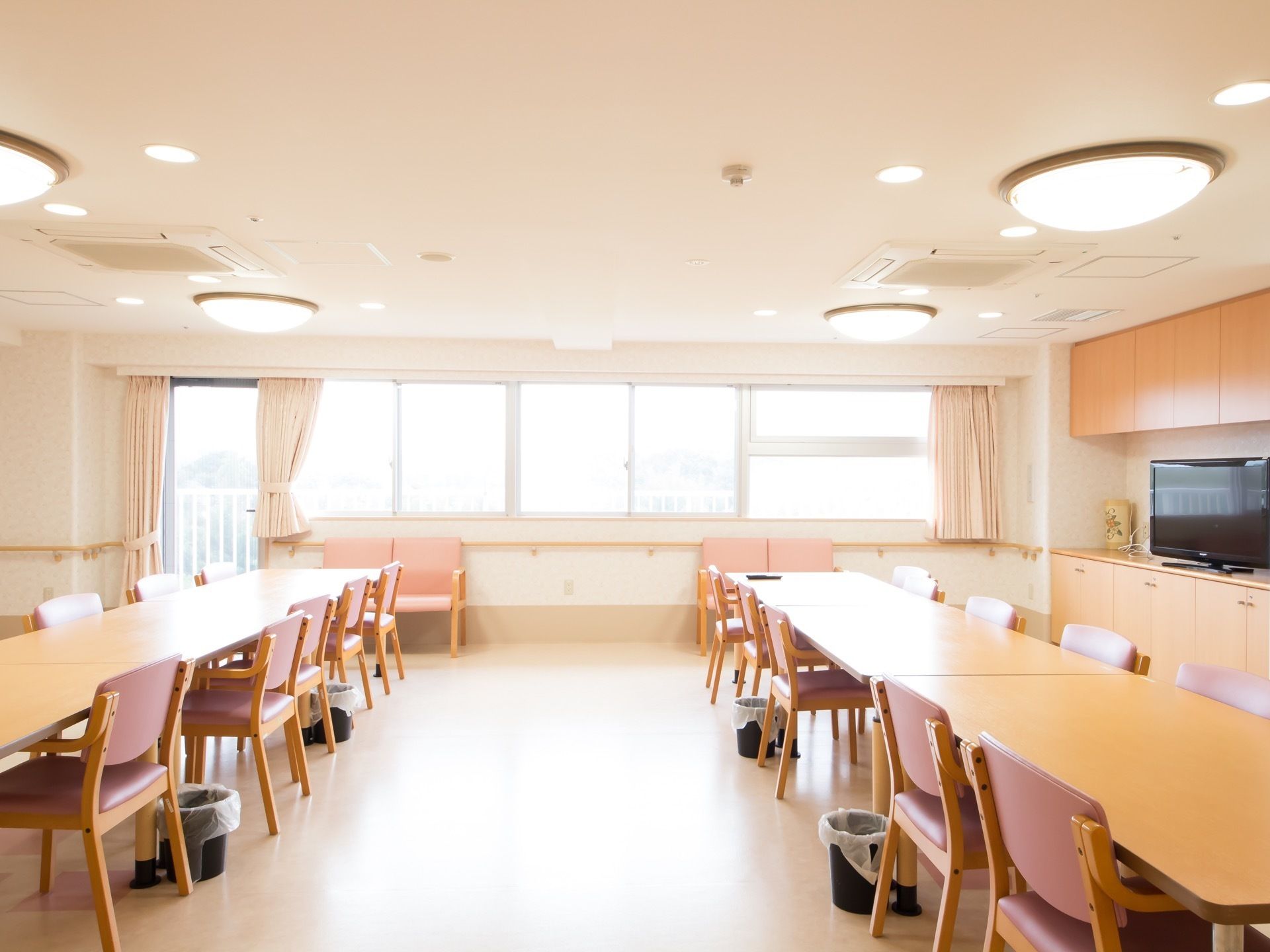 食堂はゆったりとした広さがあり、テーブルと椅子がたくさん並べられている。右側には、大きなテレビが設置されている。
