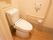 トイレは、白色を基調とした清潔感のある内装となっている。壁には、Ｌ字型の手すりが取りつけられている。