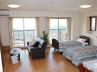 ベッドが二つ並んでいる二人用の部屋。ソファやテーブルもある様子が見える